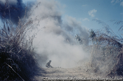 作品画像:南ヴェトナム政府軍によるラオス侵攻作戦。ラオス国境から25キロほど進んだ地点で、装甲車部隊は地雷原に触れて大音響とともに爆発した。その瞬間装甲車からたたき落とされた兵士が、手榴弾銃を右手に膝をつき、さらに左奥では負傷した兵士たちが抱き合っていた。-この連続写真の1枚が『LIFE』1971年3月12日号の表紙となった