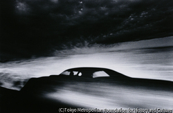 作品画像:砂漠を走る車の影