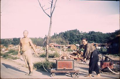 作品画像:消防ポンプを運ぶ夫婦