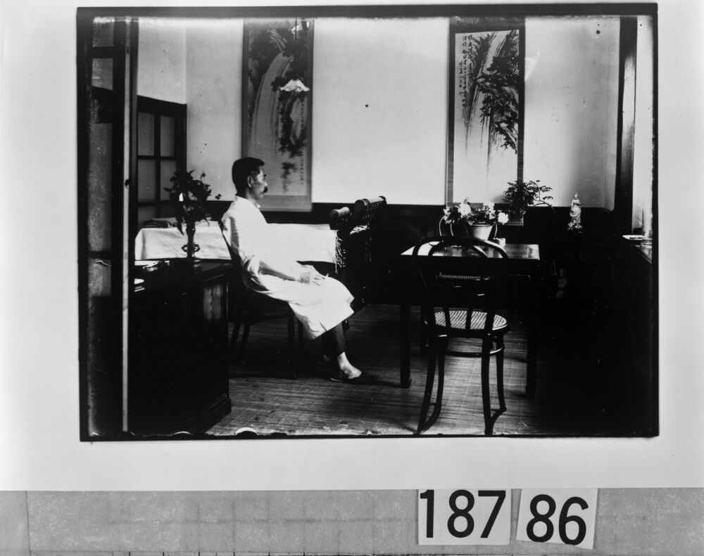 作品画像:掛軸といすに座る男性
