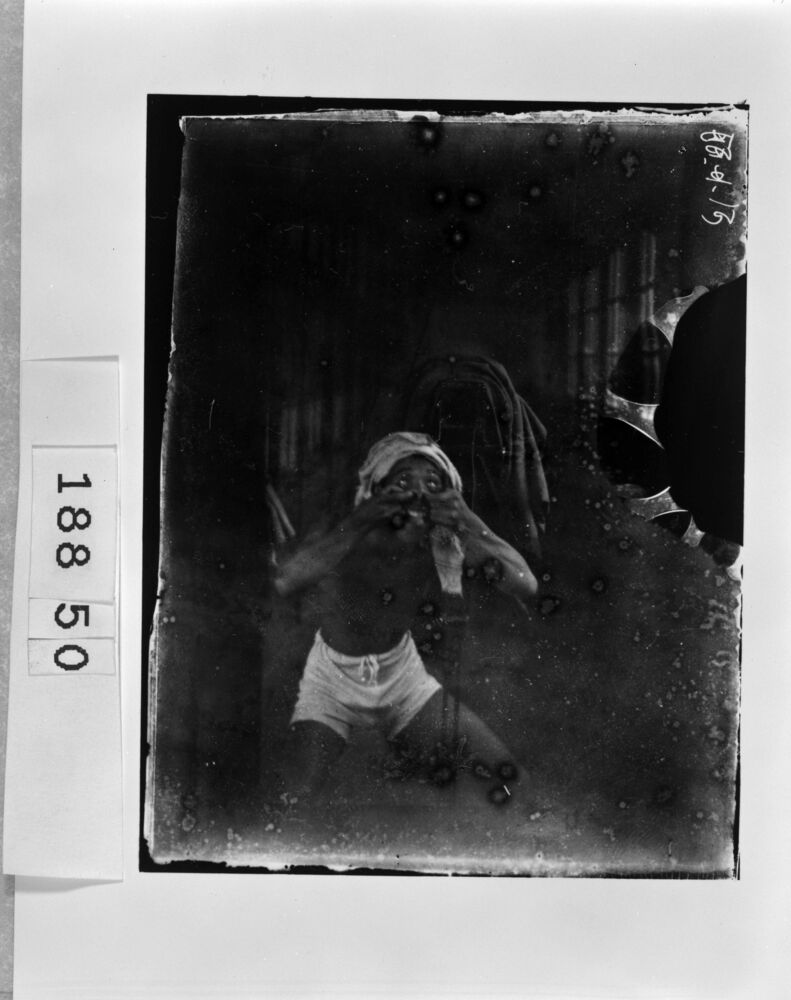 写真機の前で悪ふざけをする男性