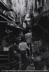 作品画像:西成区山王。狭い路地満艦飾の洗濯物の下遊ぶ子供達