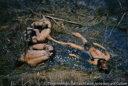 作品画像：政府軍陣地を攻撃した解放戦線の「三勇士」。うち一人は地雷をかかえて死んでいた。彼らは鉄条網にひっかかるような衣服はつけず、ふんどしだけで突入する