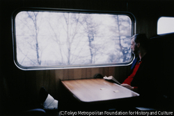 作品画像：ダブリン発ベルファスト行き急行列車の乗客。白いギプスで固めた左足を前の座席にあげ、フレデリック・フォーサイスの『戦争の犬たち』を読んでいた
